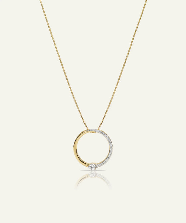 Gold necklace with a circular pendant on a white background