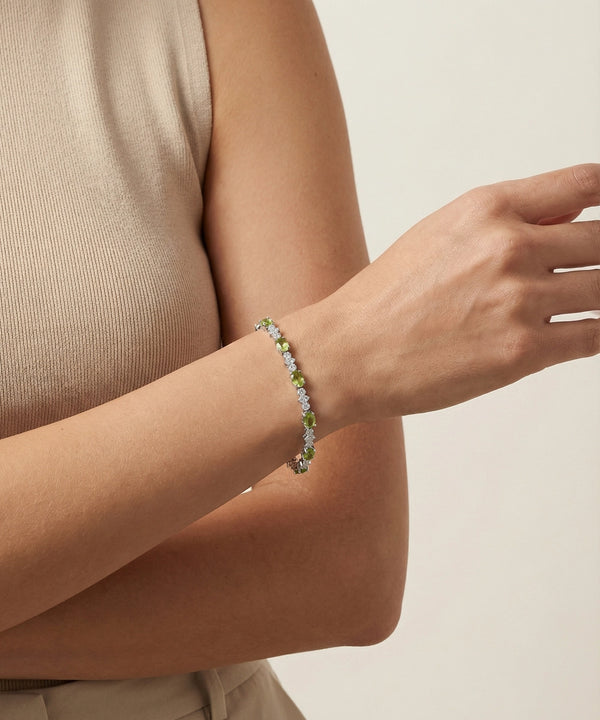 Person wearing a bracelet with small flowers on a neutral background