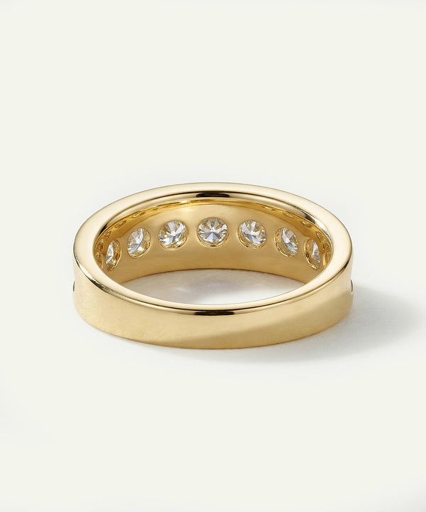 Gold ring with embedded diamonds on a light background