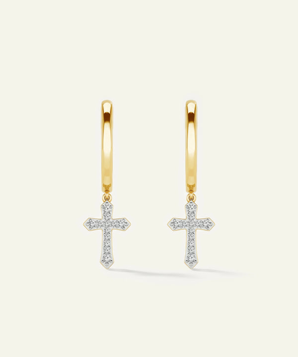 Gold hoop earrings with cross pendants on a light beige background