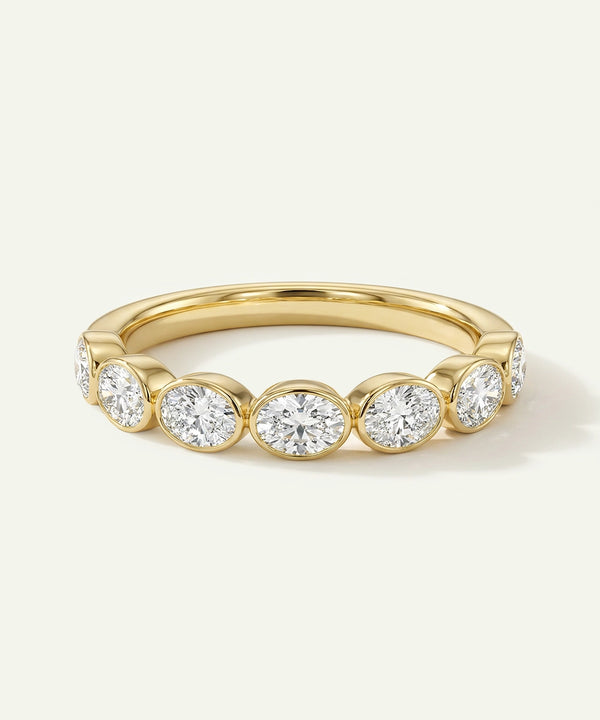 Gold ring with embedded diamonds on a light background