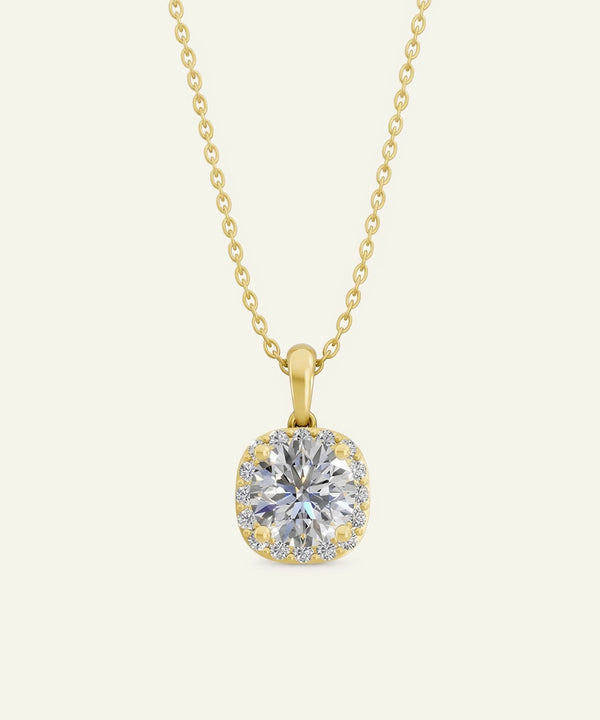 Gold necklace with a diamond pendant on a light beige background