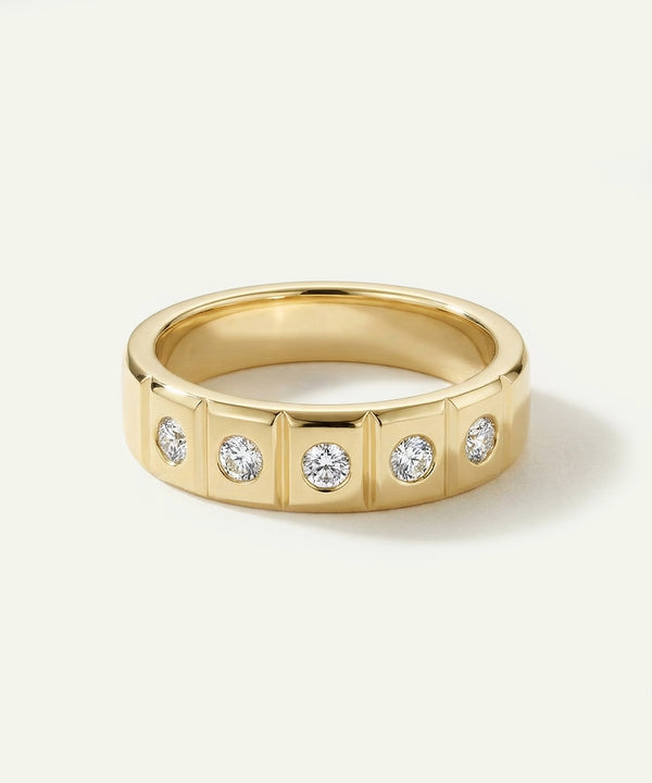 Gold ring with embedded diamonds on a light gray background