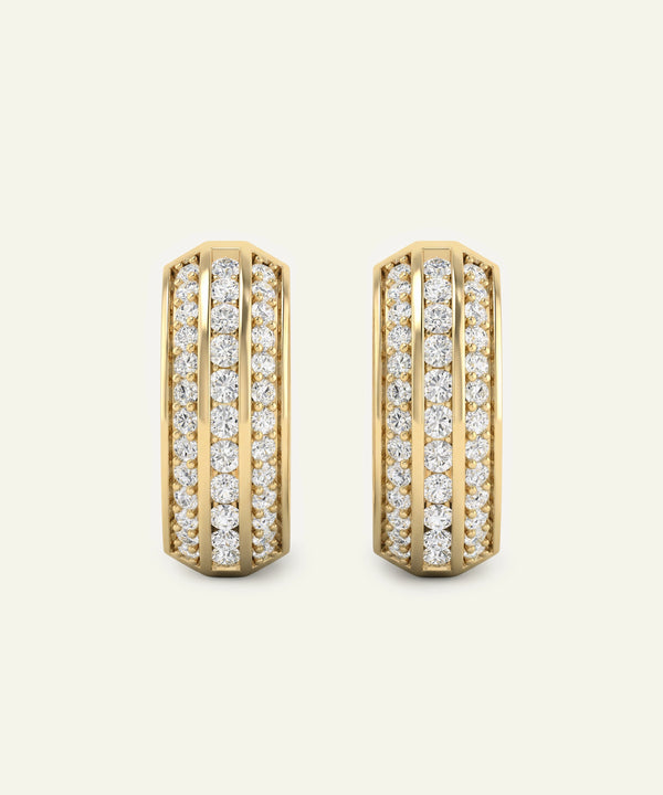 Gold hoop earrings with diamond accents on a light beige background