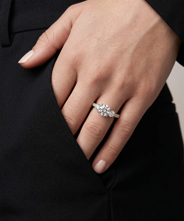 Hand wearing a diamond ring with a blurred background