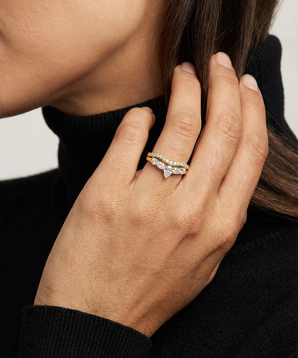 Hand wearing a diamond ring with a blurred background