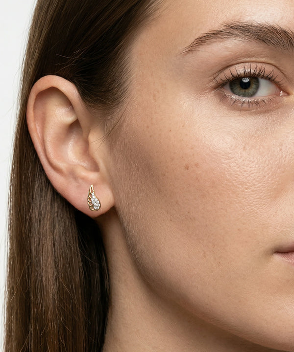Close-up of a woman wearing a silver earring with a white background
