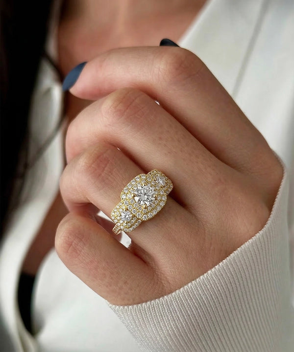 Close-up of a hand wearing a gold and diamond ring.