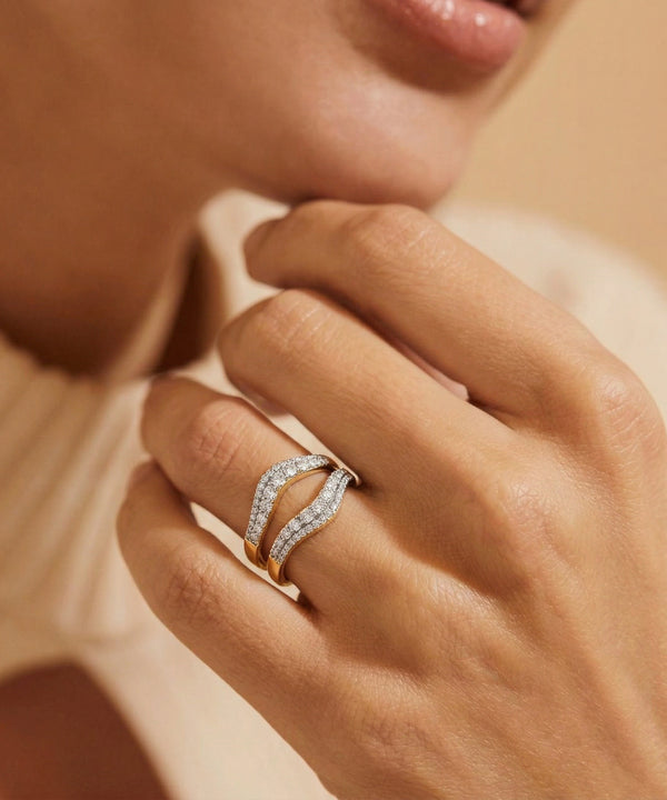 Close-up of a hand wearing a diamond ring with a soft focus background