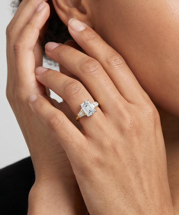Close-up of a hand wearing a diamond ring with a white background