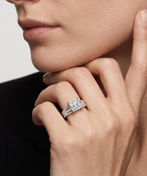 Close-up of a hand wearing a diamond ring with a blurred background