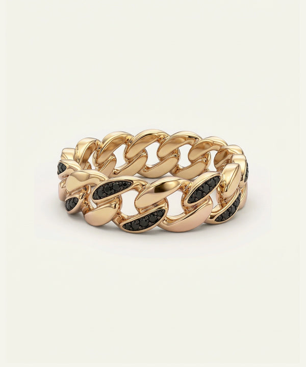 Gold chain-style ring with black stones on a beige background