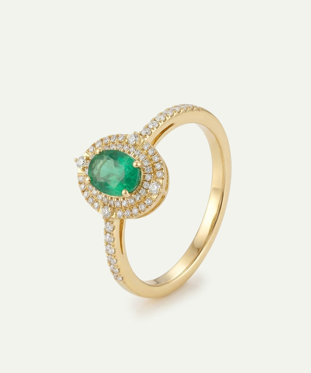 Gold ring with a green gemstone on a light beige background
