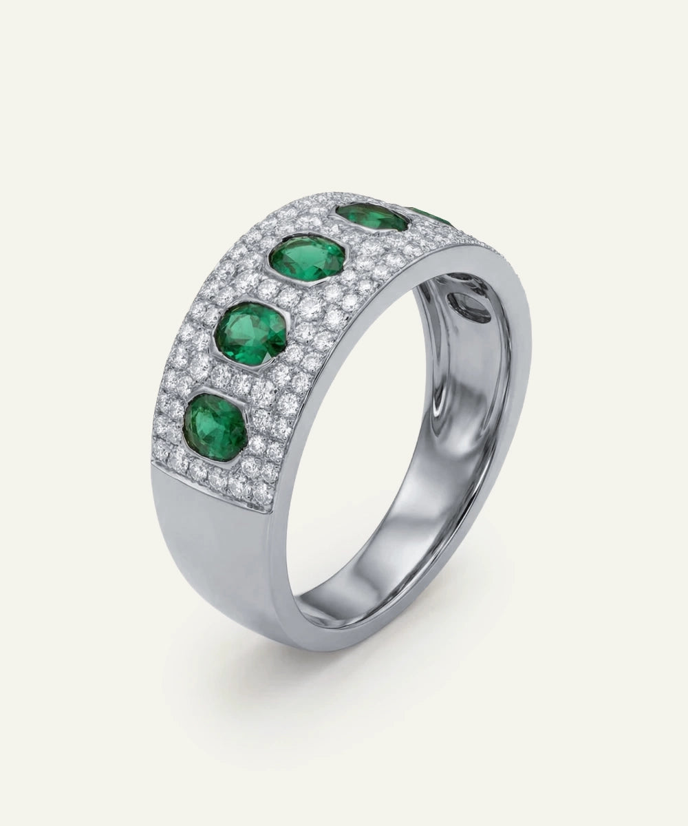 Silver ring with emerald and diamond accents on a white background