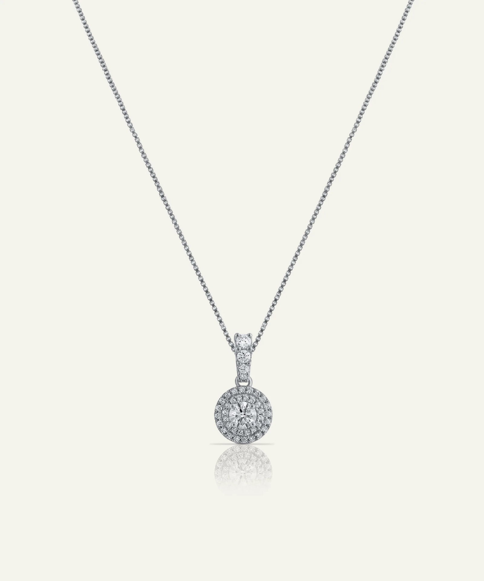 Silver necklace with a round pendant on a white background