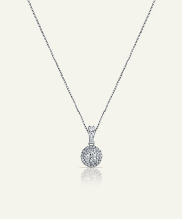 Silver necklace with a round pendant on a white background