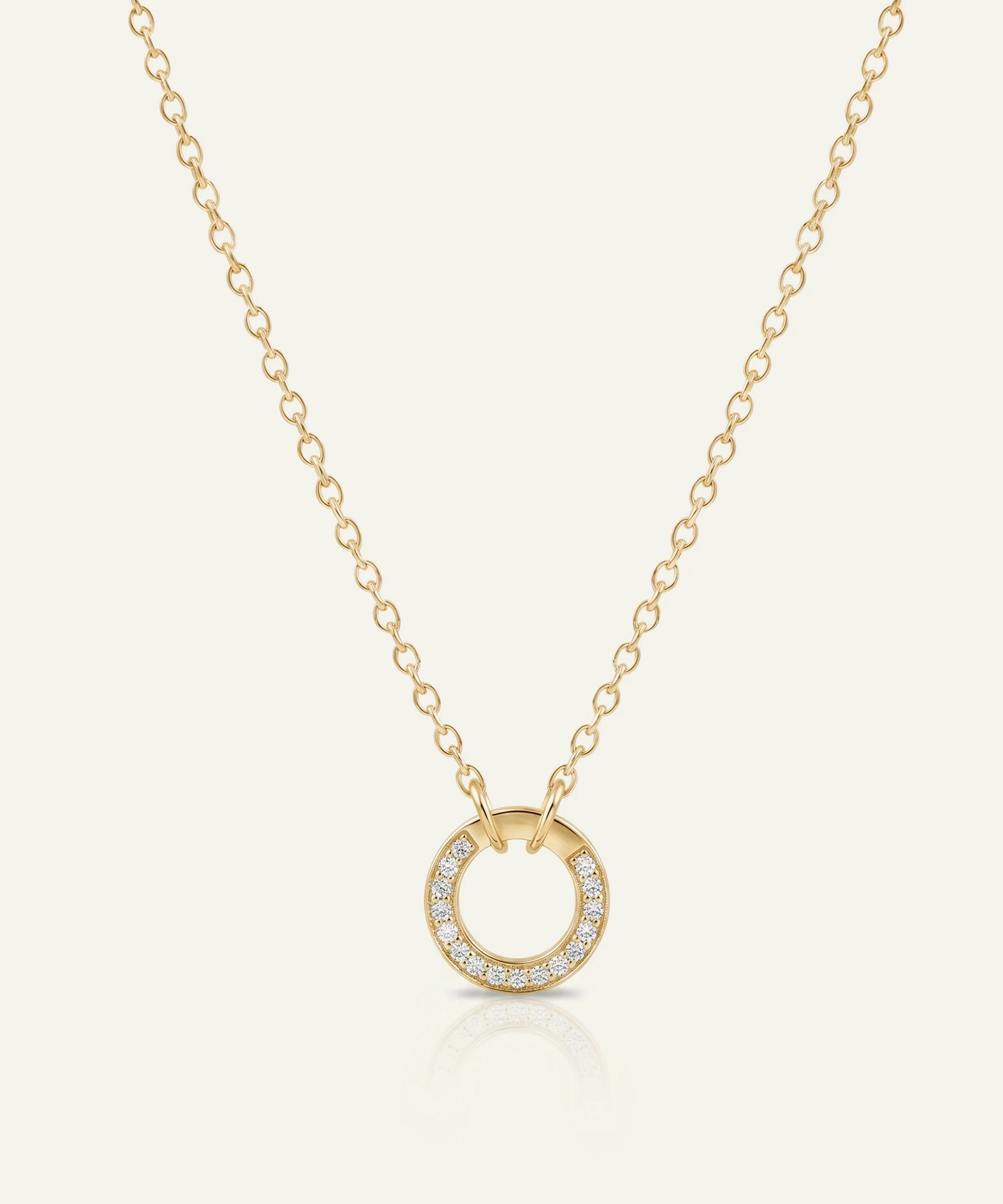 Gold necklace with a circular pendant on a white background