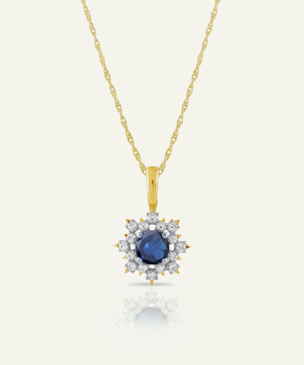 Gold necklace with a blue gemstone pendant on a white background