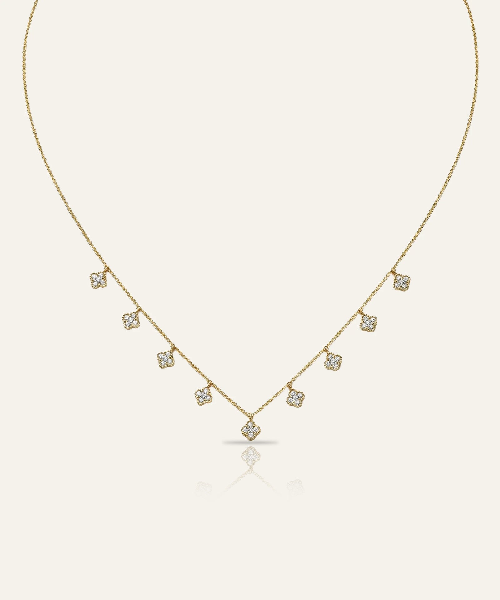 Gold necklace with small diamonds on a light beige background