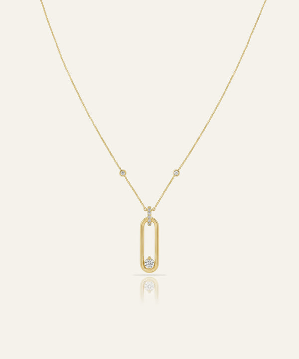 Gold necklace with a unique pendant on a light beige background