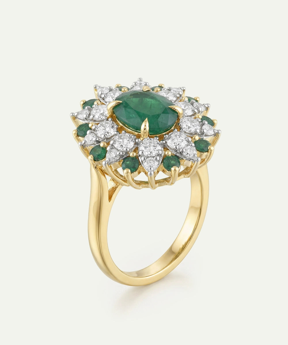 Gold ring with emerald and diamond accents on a white background