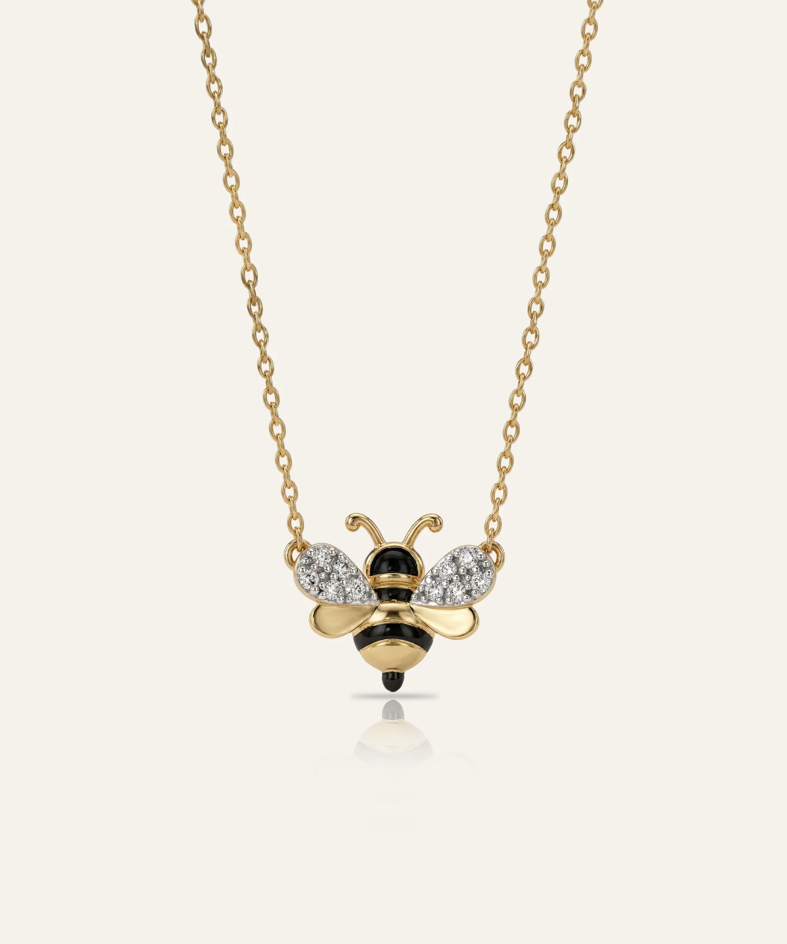 Gold bee-shaped necklace with diamond accents on a white background