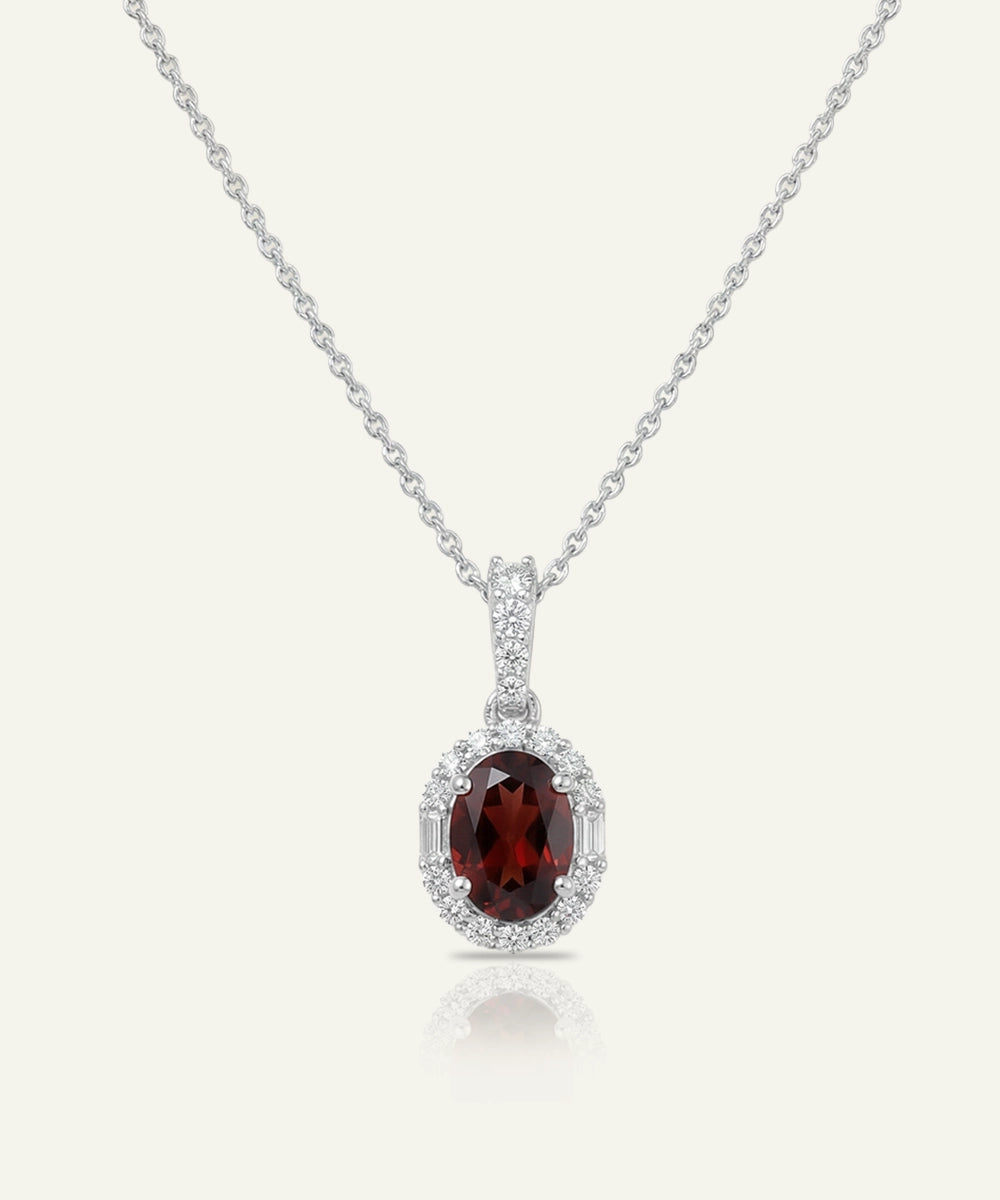 Silver necklace with a red gemstone pendant on a white background