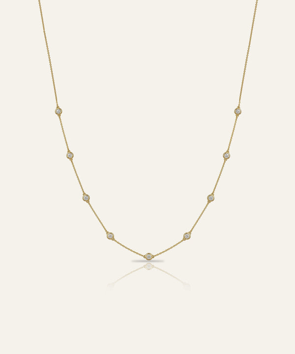 Gold necklace with small pearls on a light beige background