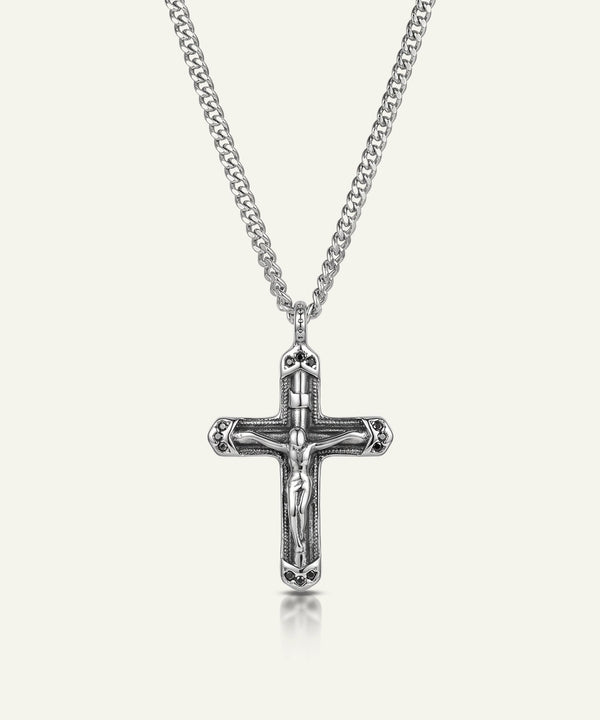 Silver crucifix pendant on a chain against a white background