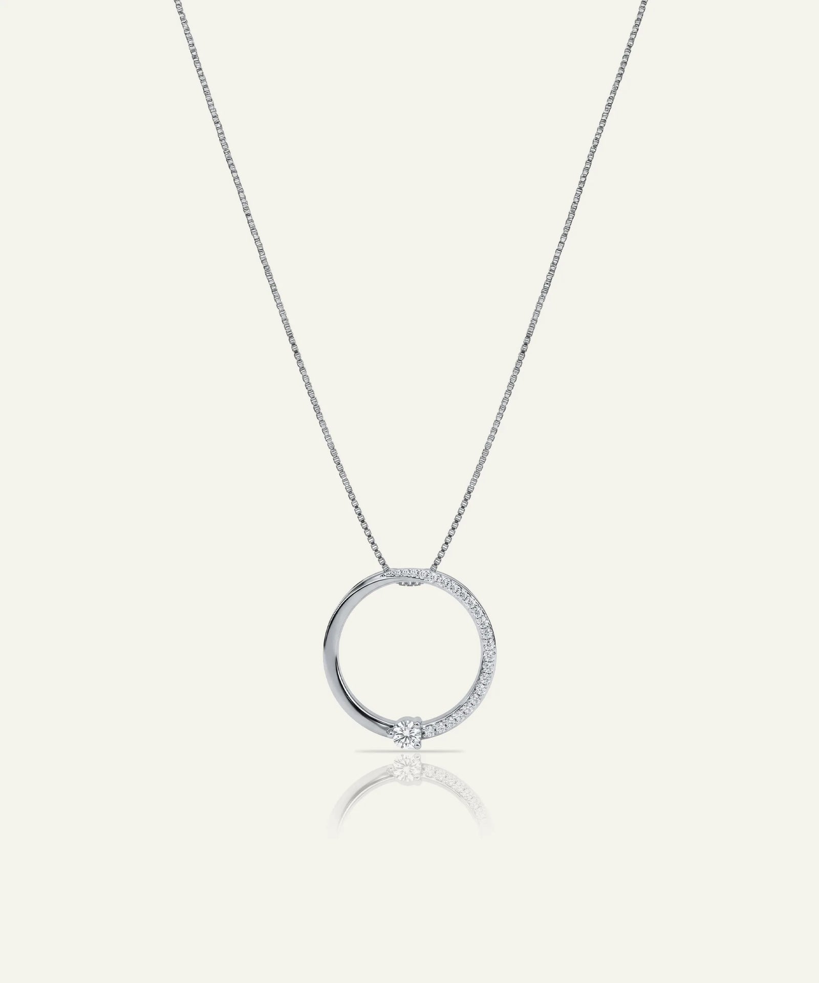 Silver necklace with a round pendant on a white background