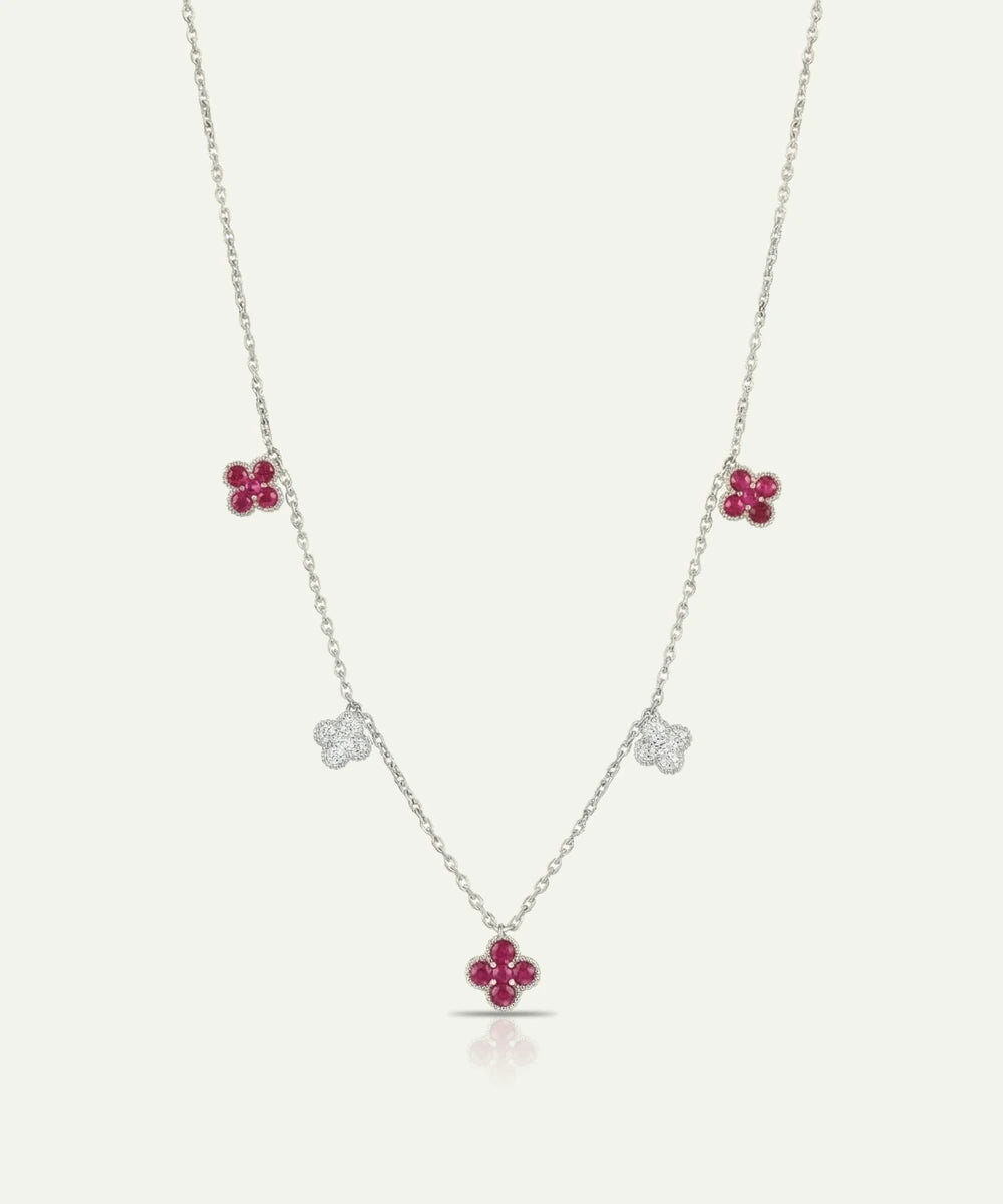 Necklace with floral pendants featuring red gemstones on a white background