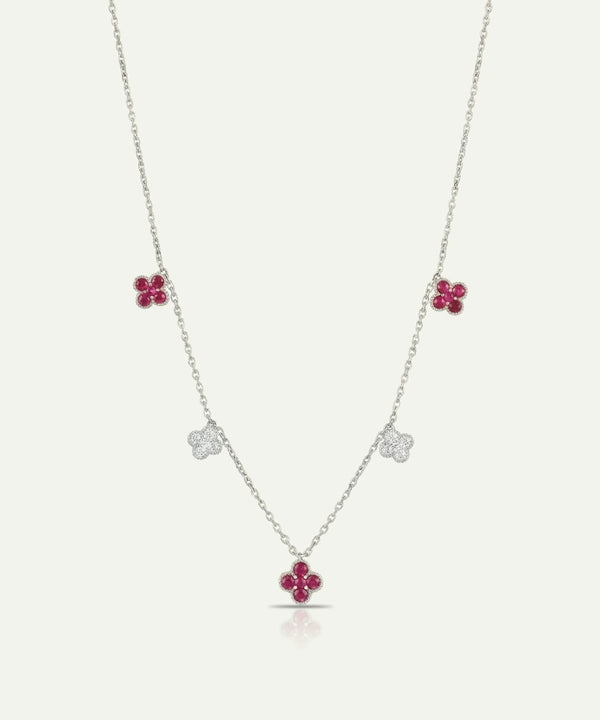 Necklace with floral pendants featuring red gemstones on a white background