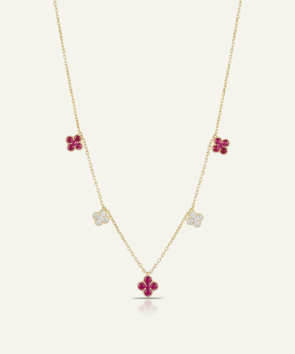 Gold necklace with red flower-shaped pendants on a white background