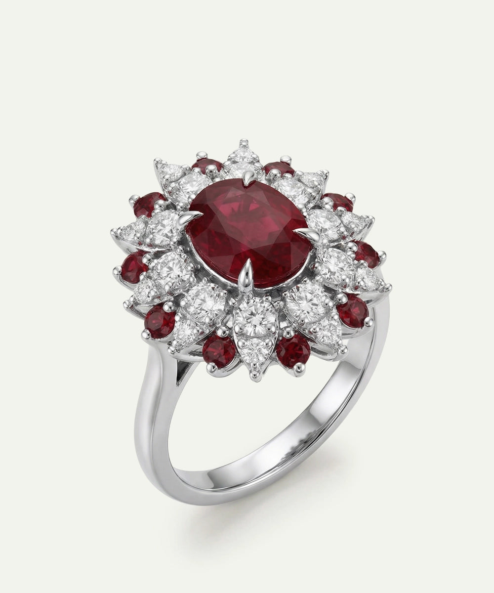 Elegant ring with a large red gemstone and smaller red stones on a white background