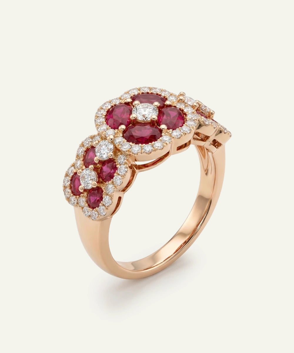 Rose gold ring with red gemstones and diamonds on a white background