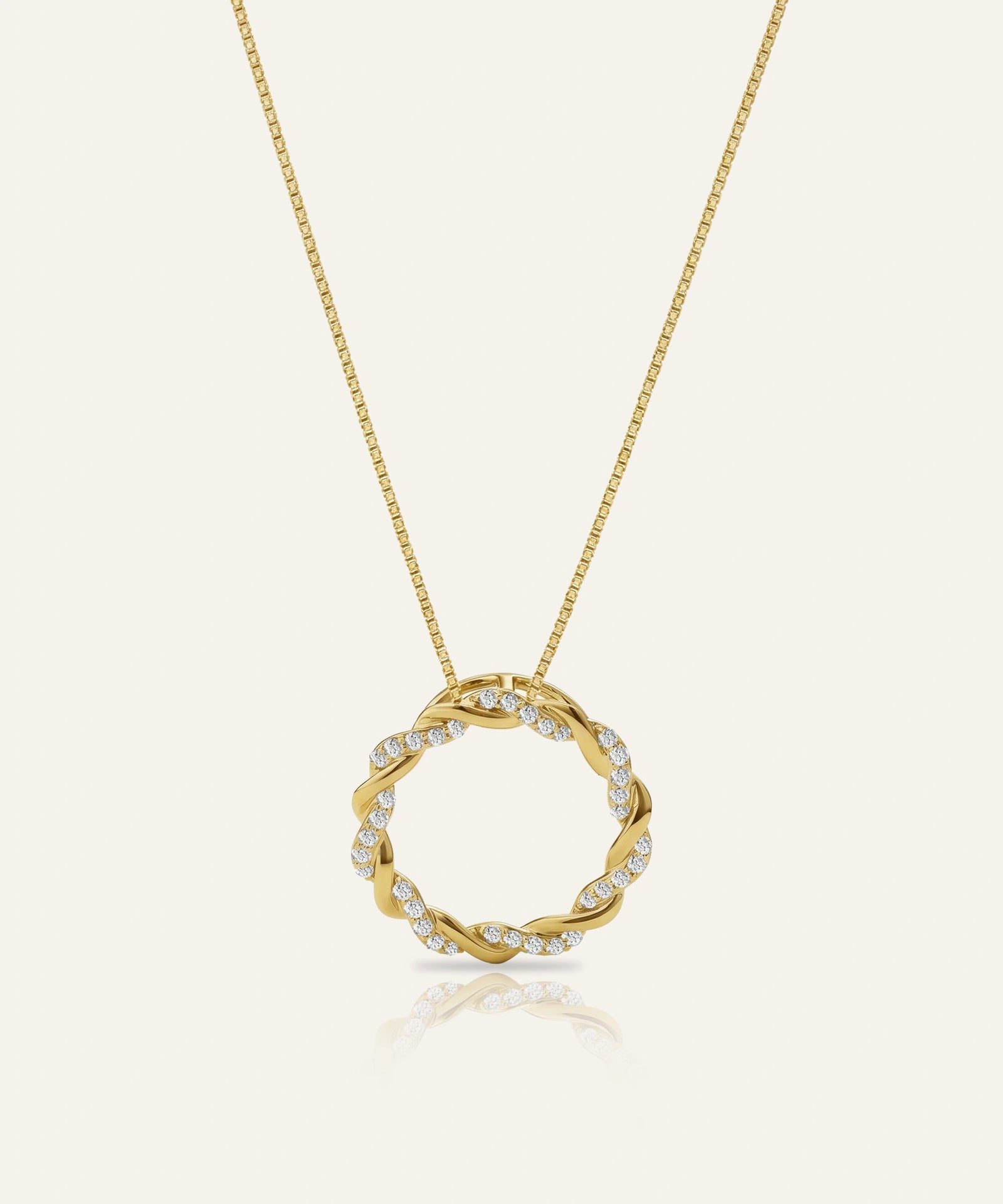Gold necklace with a circular pendant on a white background