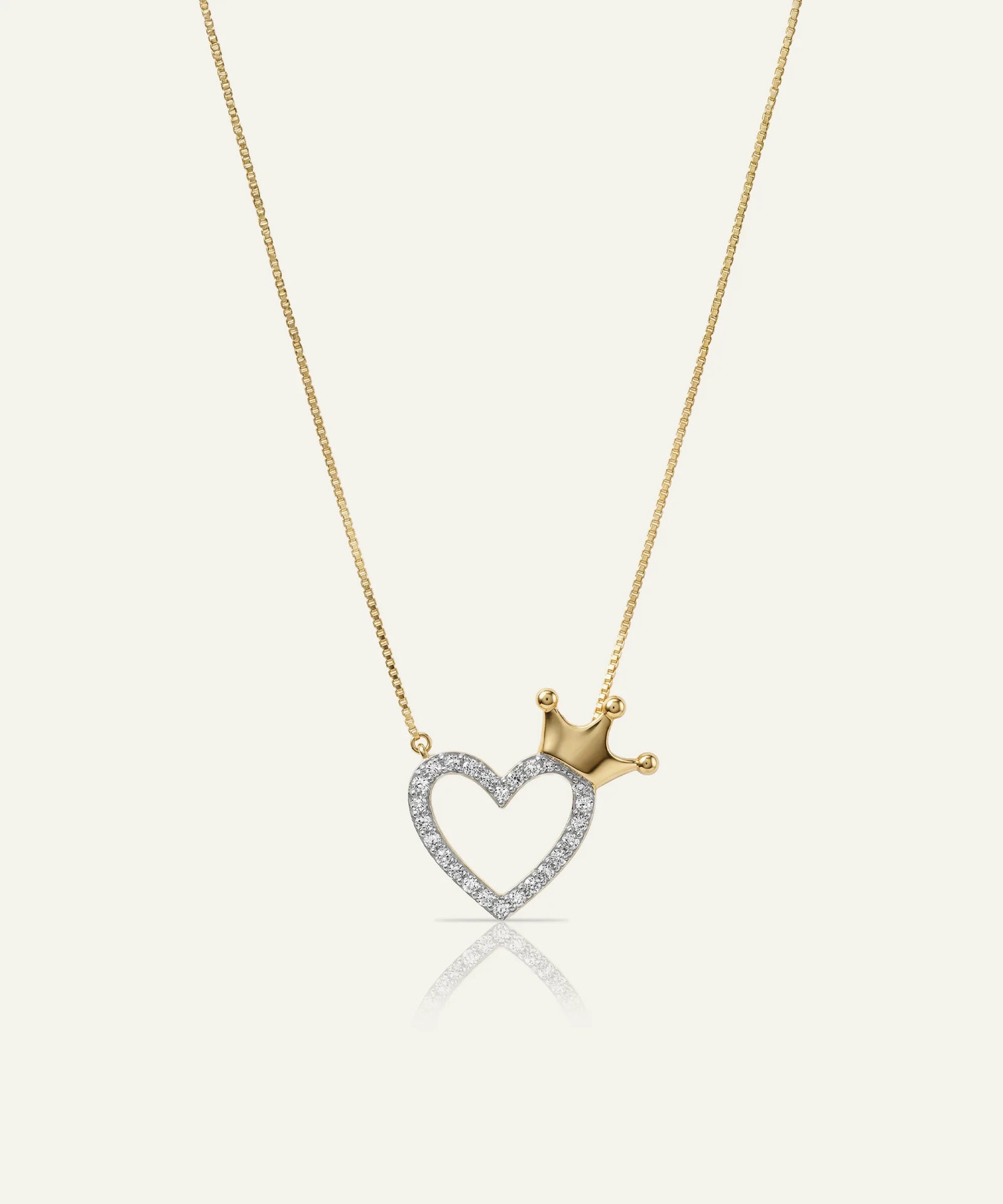 Gold necklace with a heart-shaped pendant and crown on a white background