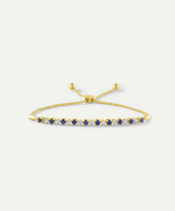Gold bracelet with blue stones on a white background