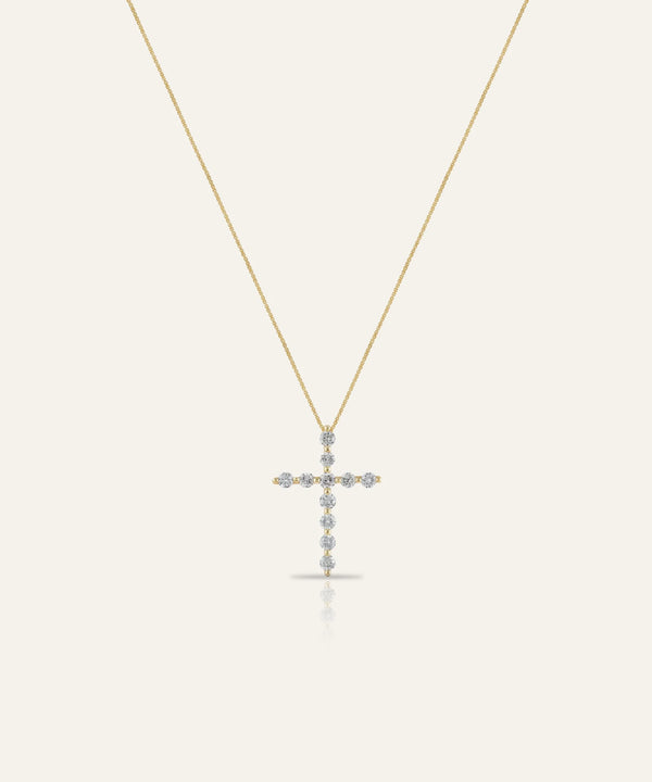 Gold cross necklace with small stones on a white background