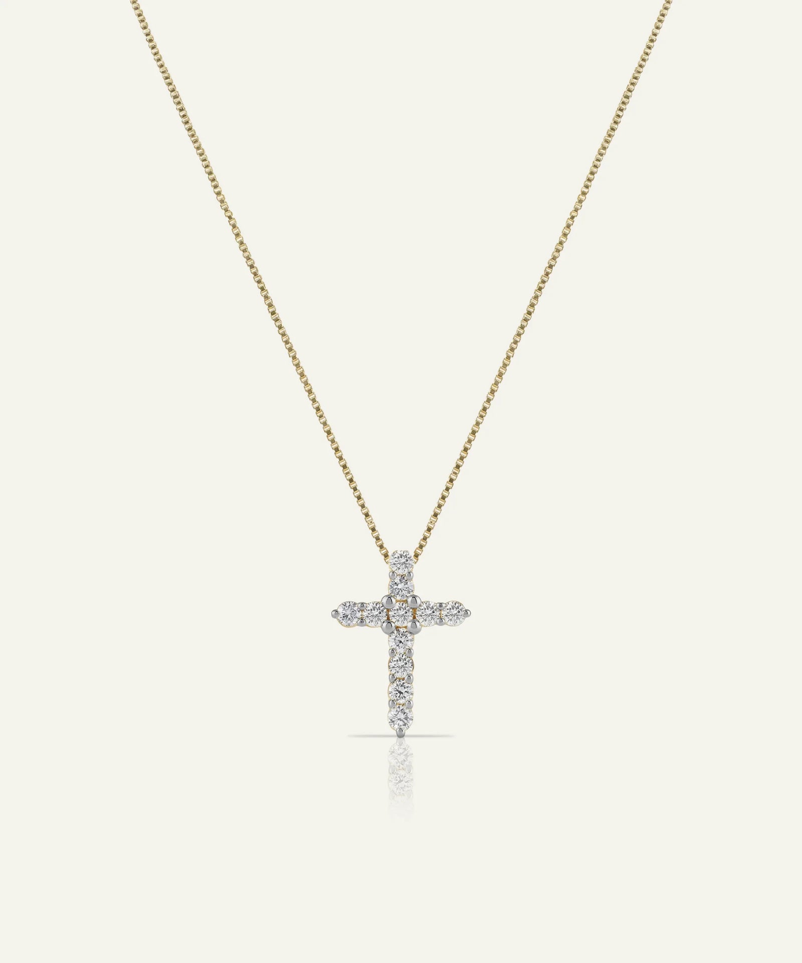 Gold necklace with a diamond cross pendant on a white background