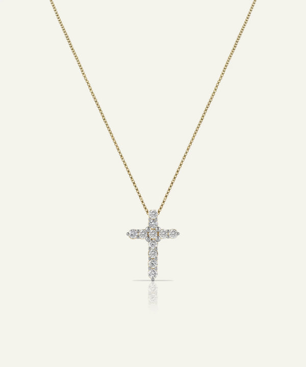 Gold necklace with a diamond cross pendant on a white background
