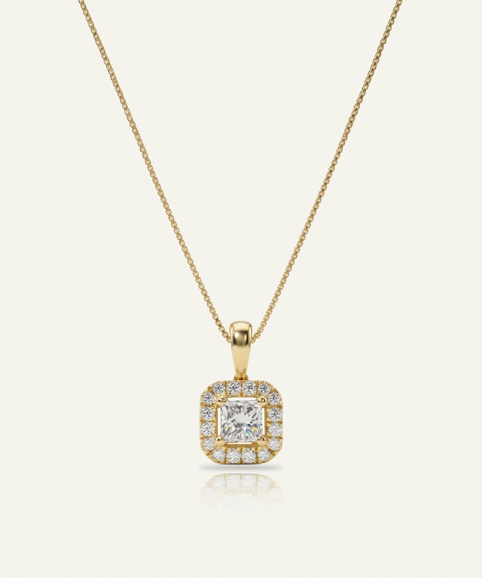 Gold necklace with a diamond pendant on a white background