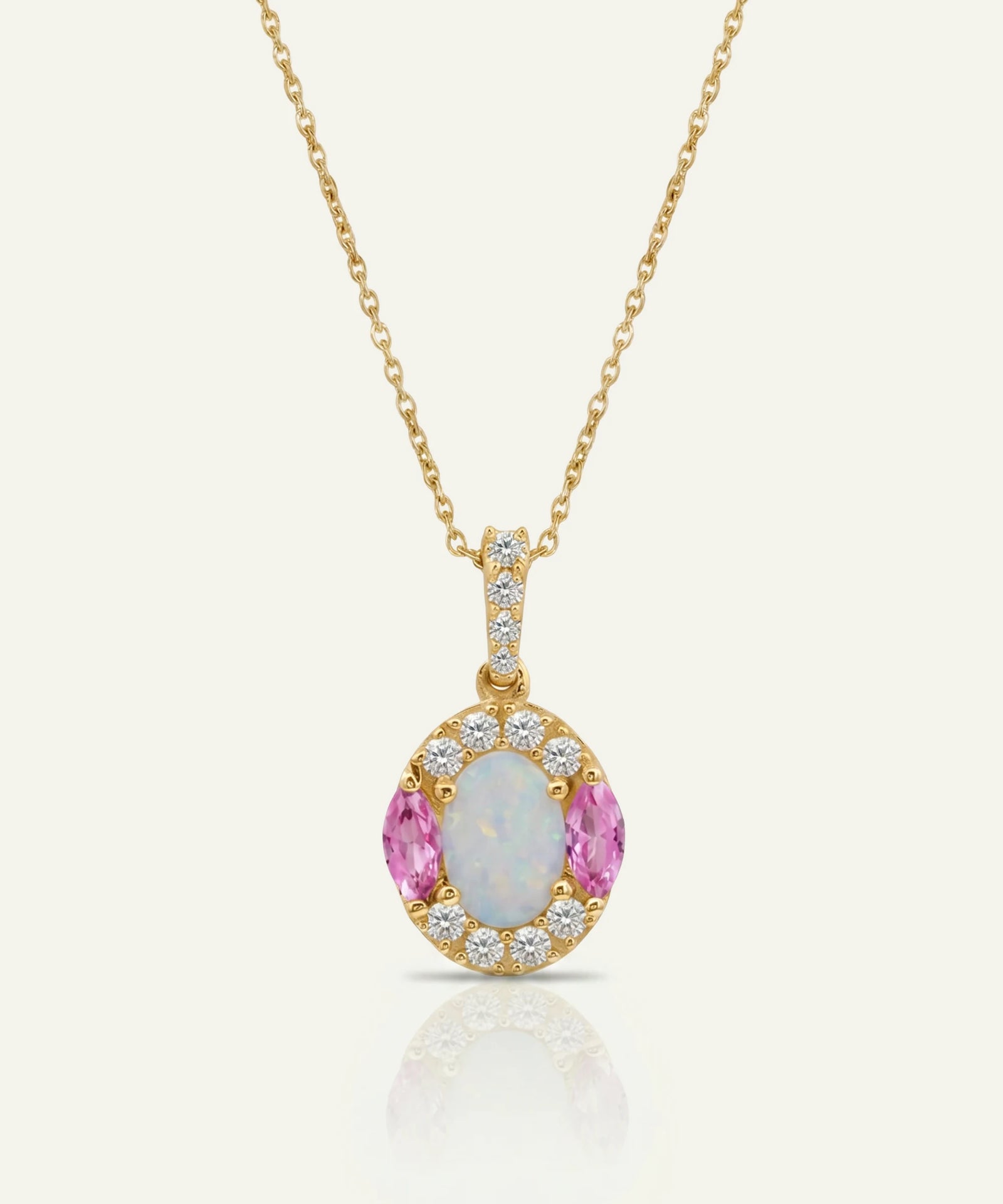 Gold necklace with a pendant featuring pink gemstones and diamonds on a white background