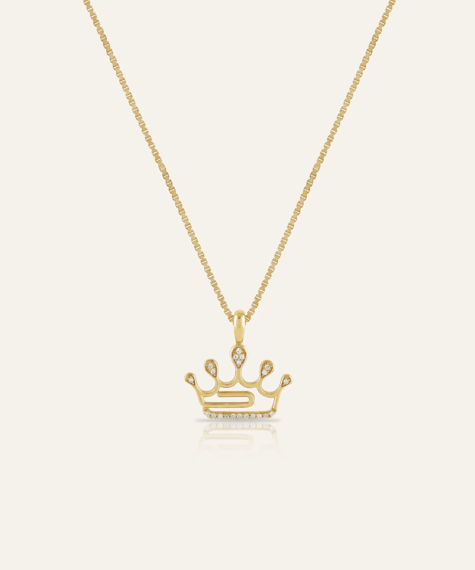 Gold crown pendant necklace on a white background