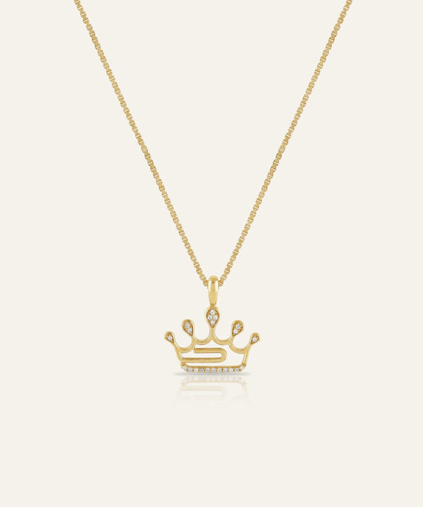 Gold crown pendant necklace on a white background