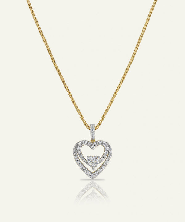 Heart-shaped diamond pendant on a gold chain against a white background