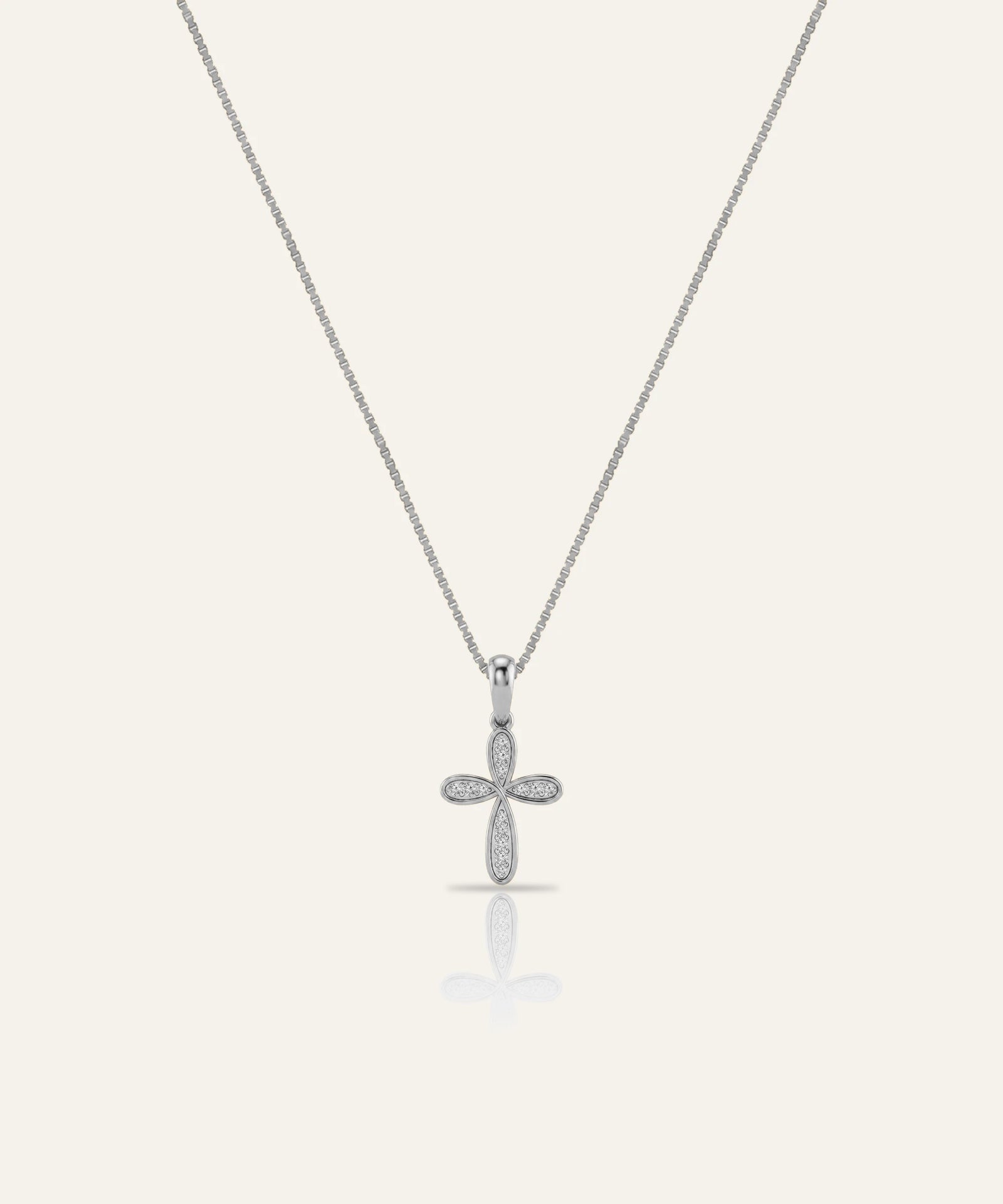 Silver cross pendant necklace on a light gray background