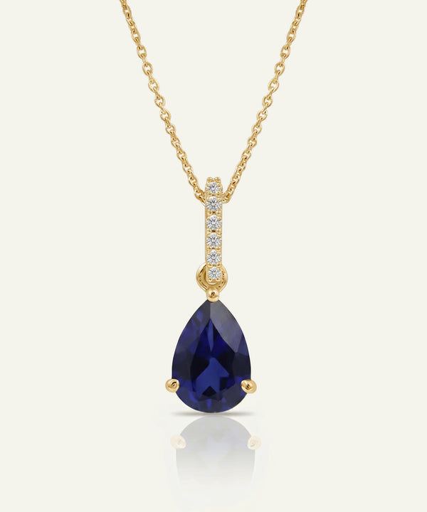 Gold necklace with a hexagonal pendant on a white background