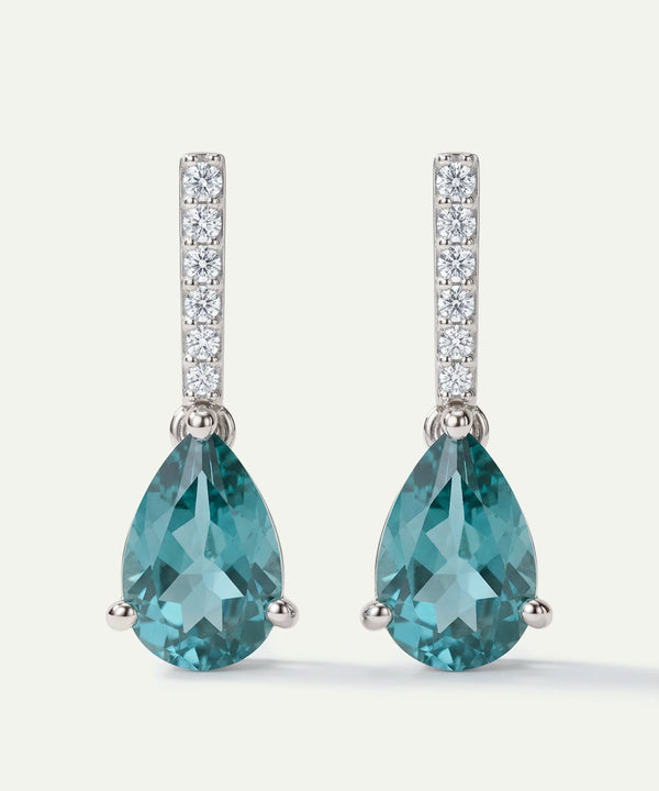Teal pear-shaped gemstone earrings with diamond accents on a white background