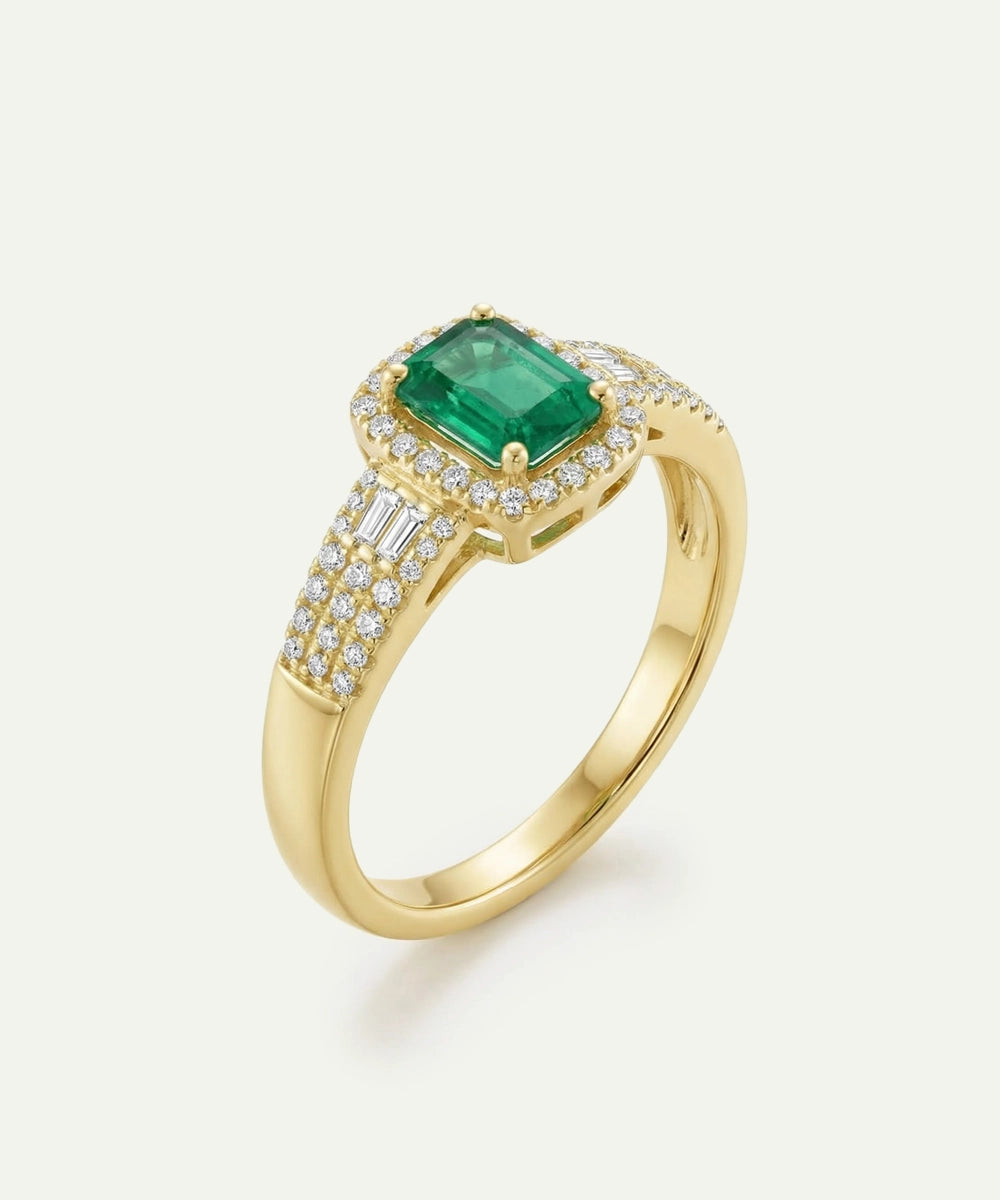 Gold ring with a green gemstone on a white background